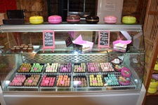 Bunt gefärbte Macarons, ein französisches Baisergebäck mit Füllung, in der Auslage eines Geschäftes in Saint-Emilion.