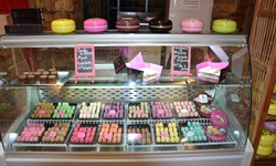 Bunt gefärbte Macarons, ein französisches Baisergebäck mit Füllung, in der Auslage eines Geschäftes in Saint-Emilion.