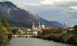 Der majestätische inn strömt fast direkt am Innsbrucker Dom vorbei, der zu Füßen einer herrlichen Bergkulisse liegt.