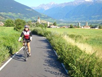 Eine Radfahrerin auf dem Etschtal-Radweg bei Mals im Vinschgau.
