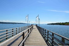 Ein hölzerner, von blau-weißen Fahnen gesäumter Steg im Starnberger See.