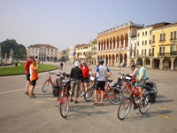 Eine Radlergruppe macht vor einigen Palazzi in Padua Pause.