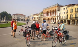 Eine Radlergruppe macht vor einigen Palazzi in Padua Pause.