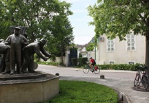 Ein Radfahrer passiert die Statue des Vignerons in Puligny-Montrachet.