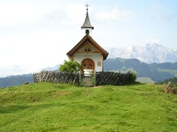 Eine idyllisch inmitten grüner Wiesen gelegene kleine Kapelle am Tauern-Radweg.