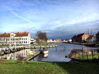 Hafen in Tönning mit zwei angelegten Booten und einem Segelschiff