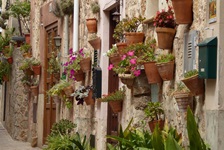 Mit Blumentöpfen geschmückte Hausfassaden in einem toskanischen Ort verströmen idyllisches Flair.