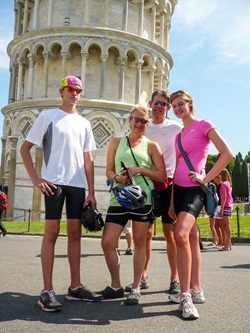 Eine Radlergruppe posiert von dem schiefen Turm von Pisa