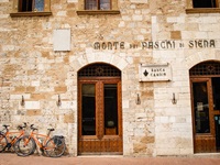 Zwei orangene Fahrräder lehnen an einem Haus in Siena