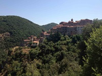 Blick auf ein toskanisches Dorf auf einem bewachsenen Berg in der Toskana