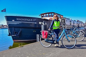 Eine Reiseleiterin der Tulpentour steht mit zahlreichen Fahrrädern an der Anlegestelle vor der MS Magnifique IV