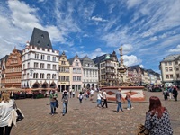 Blick auf die gut besuchte Fußgängerzone von Trier mit ihrem eindrucksvollen Brunnen