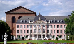 Blick auf den rosa-weißen Palast mit Parkanlage in Trier