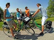 Eine Gruppe von Radlern macht eine Pause auf einem Radweg, der eine tolle Aussicht bietet