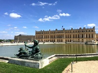Die Statue des Meeresgottes Poseidon vor der Fassade des Prachtschlosses Versailles.