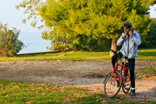 Ein Radfahrer hat auf einem Schotterweg in Italien angehalten, um seinen Helm neu zu fixieren.