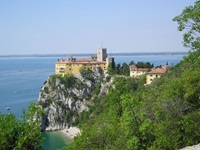 Das wunderschön auf einem Felsen am Meer gelegene und von Bäumen umrahmte Neue Schloss von Duino.