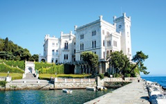 Hecken, Olivenbäume und ein See umgeben das schneeweiße, direkt am Meer gelegene Castello Miramare in Duino.