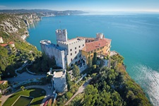 Das auf einer grün bewachsenen Klippe gelegene Schloss von Duino.