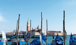 Die berühmten Gondeln Venedigs schaukeln im Wasser, im Hintergrund der Campanile und die Kirche von San Giorgio Maggiore.