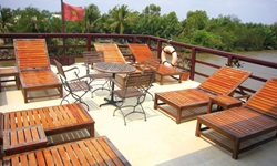 Das Sonnendeck der Funan Cruise mit Holzliegen und einem Bistrotisch