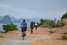 Eine Radlergruppe fährt an der Ha Long Bucht in Vietnam entlang