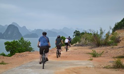 Eine Radlergruppe fährt an der Ha Long Bucht in Vietnam entlang