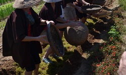 Einige Schüler in einer Kochschule in Hoi An in Vietnam hantieren mit Sieben, die wie Körbe aussehen.