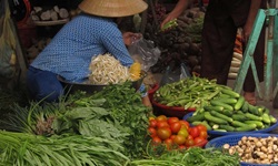 Ein Mann kauft Gemüse auf einem vietnamesischen Marktstand