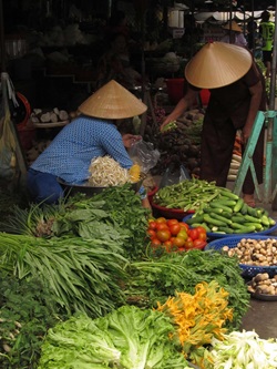 Ein Mann kauft Gemüse auf einem vietnamesischen Marktstand