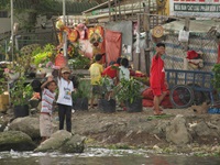 Kinder am Ufer von einer Siedlung im Mekong Delta in Vietnam winken in die Kamera