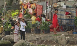 Kinder am Ufer von einer Siedlung im Mekong Delta in Vietnam winken in die Kamera