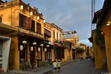 Eine belebte Gasse in Vietnam mit den typischen gelben Häusern.