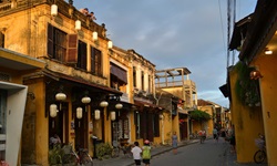 Eine belebte Gasse in Vietnam mit den typischen gelben Häusern.