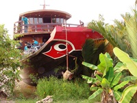 Die rote Dschunke Funan Cruise (ehemals Le Cochinchine) mit ihren charakteristischen aufgemalten Augen im Mekong Delta in Vietnam