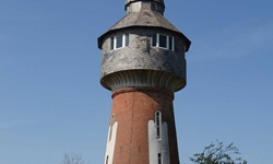 Blick auf einen Wasserturm, der aus roten Ziegeln gebaut wurde, auf dem Nordseeküstenradweg von Hamburg nach Sylt