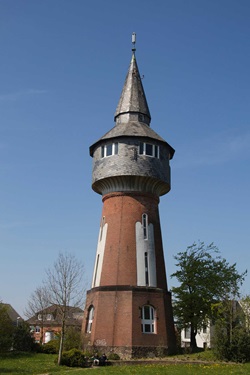 Blick auf einen Wasserturm, der aus roten Ziegeln gebaut wurde, auf dem Nordseeküstenradweg von Hamburg nach Sylt
