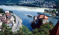 Schiffe passieren das Drei-Flüsse-Eck in Passau - im Vordergrund die Donau, rechts der Inn.