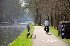 Radfahrer fährt auf einem Radweg neben einem Fluss im Elsass entlang