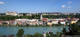 Blick auf das idyllisch an der Salzach gelegene Burghausen mit der Pfarrkirche St. Jakob, links oben im Hintergrund die namensgebende Burganlage.