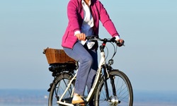 Eine Radlerin bei Prien, im Hintergrund der Chiemsee.
