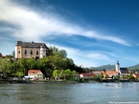 Schöne Stadtansicht von Grein mit dem Donauufer, Schloss Greinburg und der Pfarrkirche.