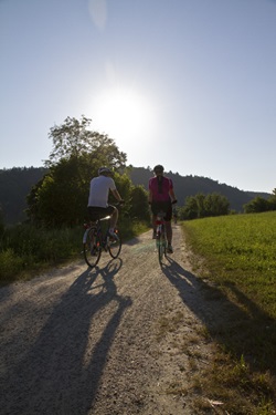 Zwei Radler auf dem Benedikt-Radweg genießen die reizvolle, von Wiesen und Wäldern geprägte Landschaft.