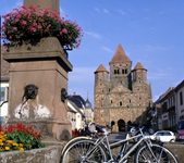 Zwei Fahrräder lehnen an einem Brunnen im verlockenden Elsass