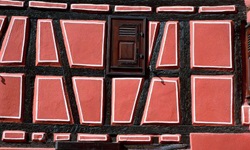 Blick auf eine rötliche Fachwerkhausfassade in Colmar