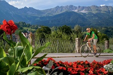 Ein Radfahrer auf dem Inn-Radweg vor einem herrlichen Bergpanorama.