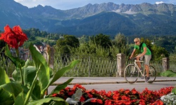 Ein Radfahrer auf dem Inn-Radweg vor einem herrlichen Bergpanorama.