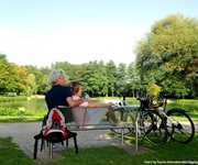 Zwei Radfahrer machen auf einer Bank am Donauufer eine Pause