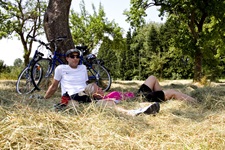 Zwei Radfahrer auf einer Heuwiese unter einem schattingen Baum auf der Radreise von Ulm nach Regensburg
