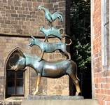 Die Bronzestatue der Bremer Stadtmusikanten neben dem Bremer Roland.